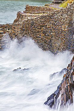 On a rising tide, evening surf pounds the historic harbour wall at Hartland Quay, on the Atlantic coast of Devon, England, United Kingdom, Europe