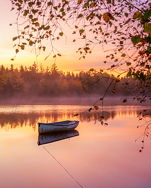 Lone boat floating on Loch Rusky at sunrise, Highlands, Scotland, United Kingdom, Europe