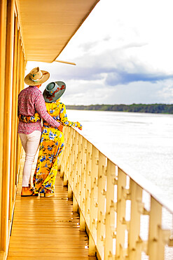 Couple enjoying the view of the Amazon River aboard a river boat, Peru, South America