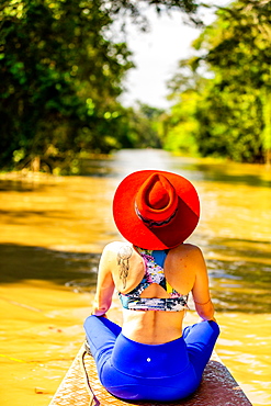 Woman searching for wildlife on the Amazon River, Peru, South America