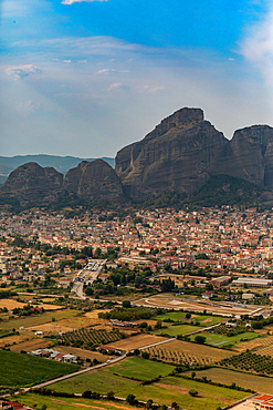 Vertical orientation view of a town below a rocky cliff, Thessaly, Greece.