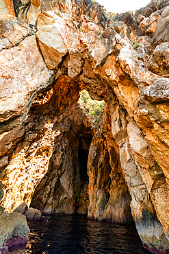 Rock arch and narrow sea cave entrance in the coastal cliffs of the Ionian Sea near Dhermi, Vlorë County, Albania, viewed from the water.