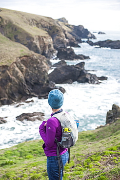 A woman hiking the coastal path on the west side of The Lizard Peninsula, Cornwall, England, United Kingdom, Europe