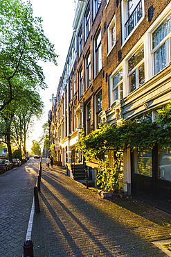 Golden hour light on canalside buildings, Amsterdam, North Holland, The Netherlands, Europe