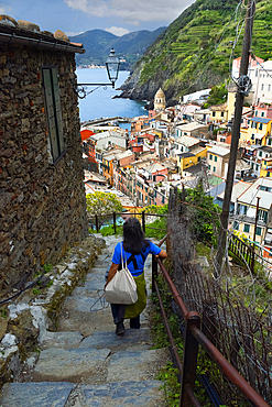 A lone tourist approaches Vernazza, a coastal town in the province of La Spezia, Cinque Terre region, UNESCO World Heritage Site, Liguria, Italy, Europe