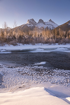 Winter sunrise with frozen Bow River and Three Sisters, Canmore, Alberta, Canadian Rockies, Canada, North America