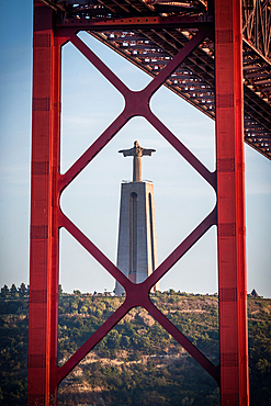 Cristo Rei statue through the 25 April Bridge in Lisbon, Portugal