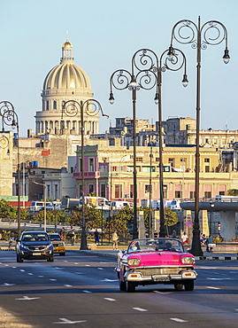 Vintage cars at El Malecon, Centro Habana and El Capitolio at sunset, Havana, La Habana Province, Cuba, West Indies, Central America