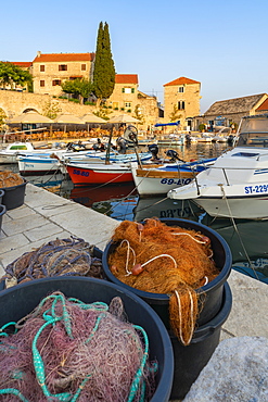 Boats and fishing nets at the pier of the town at sunset, Bol, Brac island, Split-Dalmatia county, Croatia, Europe