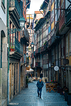 A lone man walking along a back street in Porto, Portugal, Europe