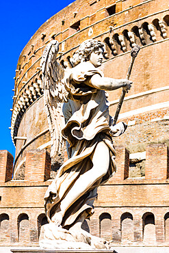 An angel statue from Ponte Sant'Angelo with Castle of the Holy Angel (Castel Sant'Angelo), Rome, Lazio, Italy, Europe