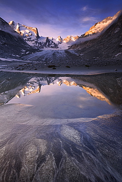 Sunrise reflected in a pond at Forno Glacier, Forno Valley, Maloja Pass, Engadine, Graubunden, Switzerland, Europe