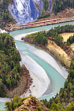 The Red Train travels along the Rhine River, Rhein Gorge (Ruinaulta), Flims, Imboden, Graubunden, Switzerland, Europe