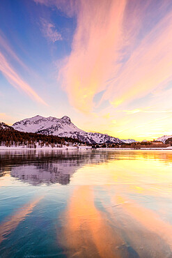 Colors of sunset reflected on the icy surface of Lake Sils, Engadine Valley, Graubunden, Switzerland, Europe