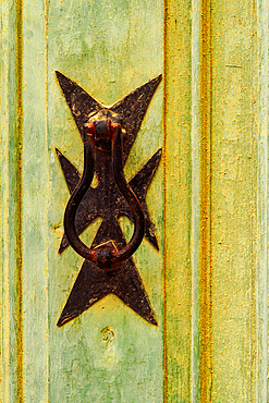 Traditional brass door knocker detail with Maltese cross design outside a building in the alleys of the old city of Birgu (Citta Vittoriosa), Malta, Mediterranean, Europe