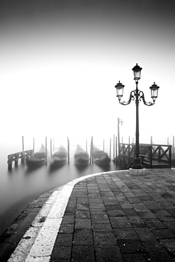 Black and white gondolas and lamp in the mist, St. Mark's Square, with Grand Canal in the background, Venice, UNESCO World Heritage Site, Veneto, Italy, Europe