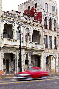 Blurred red vintage car driving along the Malecon, Havana, Cuba, West Indies, Caribbean, Central America