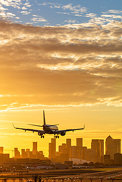 Aircraft landing at London City Airport at sunset, with Canary Wharf and O2 Arena in background, London, England, United Kingdom, Europe