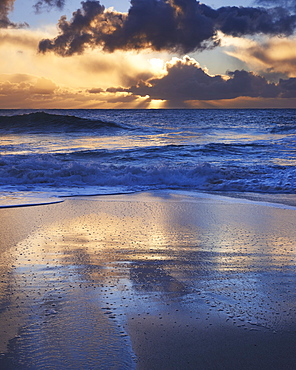 Early morning light glistening on the wet sand with dramatic clouds beyond, Porthcurno, Cornwall, England, United Kingdom, Europe