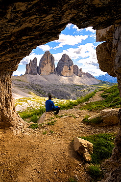 Hiker admires the three peaks of Lavaredo from the caves, Natural Park of the Three Peaks, Trentino-Alto Adige, Italy, Europe