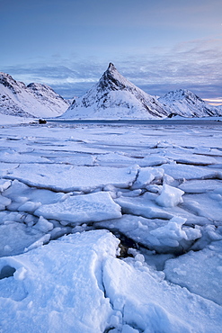 Snow covered steep mountain with ice formations in winter scene on Lofoten Islands, Arctic, Norway, Europe