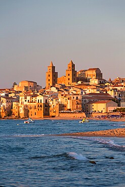 View from beach along water's edge to the town and UNESCO World Heritage Site listed Arab-Norman cathedral, sunset, Cefalu, Palermo, Sicily, Italy, Mediterranean, Europe