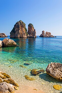 View across tranquil cove to the Faraglioni, a series of towering offshore rock stacks, Scopello, Trapani, Sicily, Italy, Mediterranean, Europe