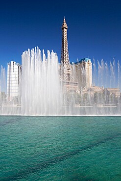 View across lake to replica Eiffel Tower at the Paris Hotel and Casino, Bellagio fountains in foreground, Las Vegas, Nevada, United States of America, North America