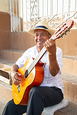 Local man singing and playing his guitar in the Plaza Mayor of Trinidad, Cuba, West Indies, Caribbean, Central America