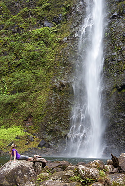 Hiker enjoying a waterfall along the famous Kalalau Trail, along Kauai's Na Pali Coast, Kauai, Hawaii, United States of America, North America