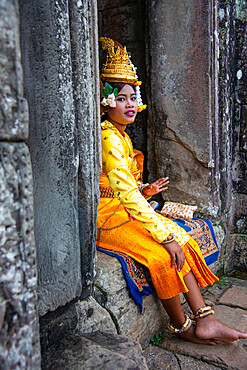 A performer taking a break among the ruins of the Angkor archaeological complex, Siem Reap, Cambodia, Indochina, Southeast Asia, Asia