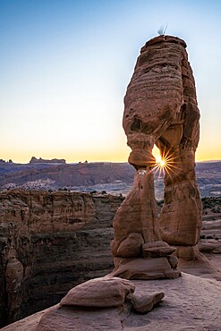 Delicate Arch at sunset with sunburst, Arches National Park, Utah, United States of America, North America