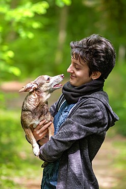 Small dog in the arms of his owner looking each other, Italy, Europe