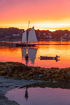 A schooner returns to dock at sunset at Bailey Island, Casco Bay, Maine, United States of America, North America