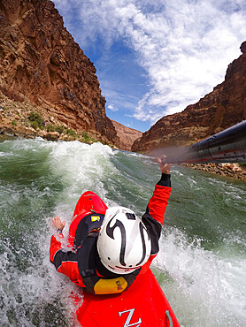 Skip Brown surfs his whitewater kayak on a glassy standing wave on the Colorado River through the Grand Canyon, Arizona, United States of America, North America