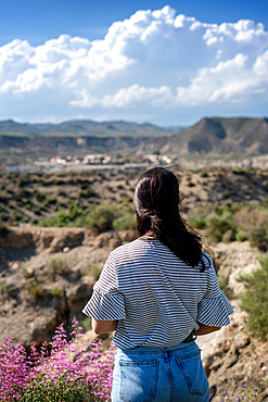 Young woman looking at Tabernas desert on a sunny day, Almeria, Andalusia, Spain, Europe