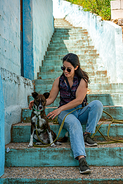 Woman with dog sitting on blue steps, Juzcar, Pueblos Blancos region, Andalusia, Spain, Europe