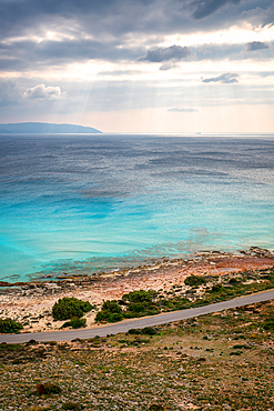 Road on the coast of elafonisos island by the beach with turquoise sea water, in Greece