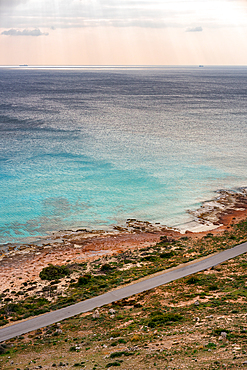 Road on the coast of elafonisos island by the beach with turquoise sea water, in Greece