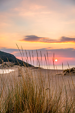 Sun setting down at the sea on a wild natural beach, in Greece