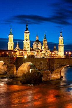 Basilica del Pilar Cathedral with stone bridge crossing Ebro River at night, Zaragoza, Aragon, Spain, Europe