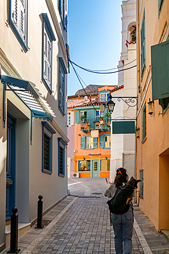 Woman with dog in a backpack walking in Nafplion historic city center in Greece