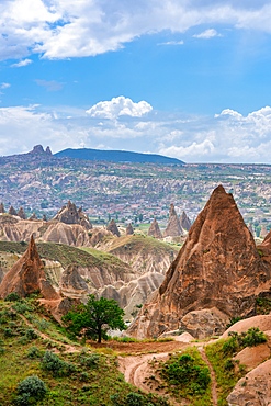 Red and rose valley landscape with colorful rock formations with Ortahisar city on the background in Cappadocia, Turkey