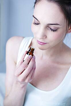 Woman smelling essential oil.