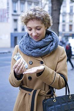 Woman applying cream on her hands.