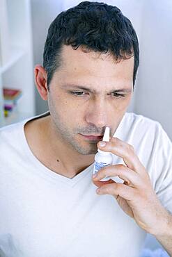 Man using nasal spray.