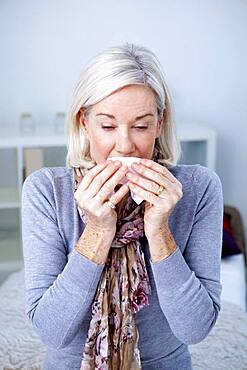 Senior woman sneezing.