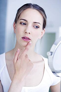 Woman looking at herself in the mirror.