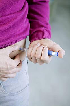 Man injecting himself with insulin.