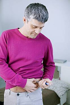 Man injecting himself with insulin.